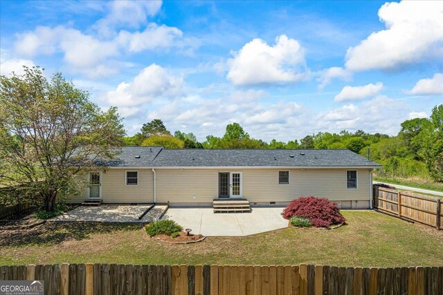 rear view of property with a patio, crawl space, entry steps, a fenced backyard, and a yard
