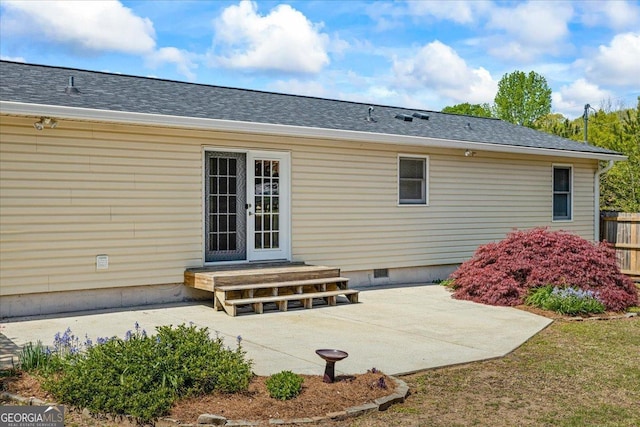 back of property with crawl space, roof with shingles, a patio area, and entry steps