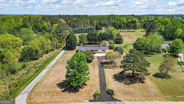 drone / aerial view featuring a wooded view