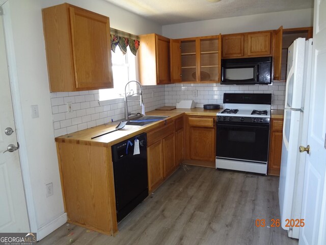 2338 Rambling Way, Lithonia, GA 30058 - kitchen with backsplash, open shelves, black appliances, light wood-style floors, and a sink