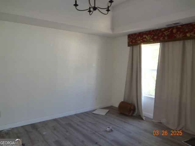 2338 Rambling Way, Lithonia, GA 30058 - unfurnished room with baseboards, a notable chandelier, wood finished floors, and a healthy amount of sunlight