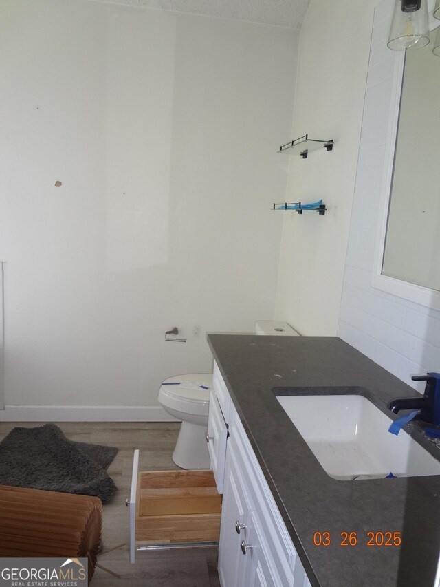 2338 Rambling Way, Lithonia, GA 30058 - bathroom featuring vanity, baseboards, toilet, and wood finished floors