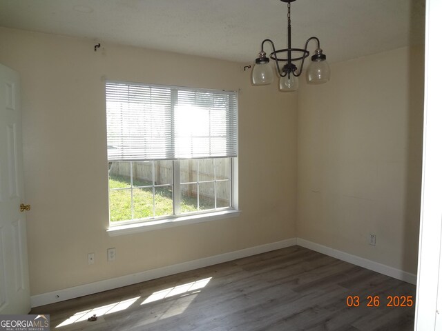 2338 Rambling Way, Lithonia, GA 30058 - spare room with a chandelier, wood finished floors, and baseboards