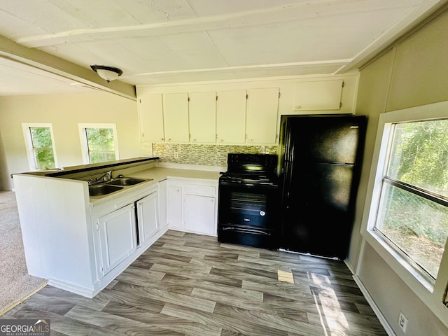 4199 Wagon Trl, Loganville, GA 30052 - kitchen featuring white cabinets, a sink, a peninsula, black appliances, and decorative backsplash