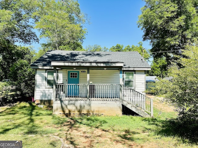 bungalow-style house featuring a front yard, a porch, and a shingled roof