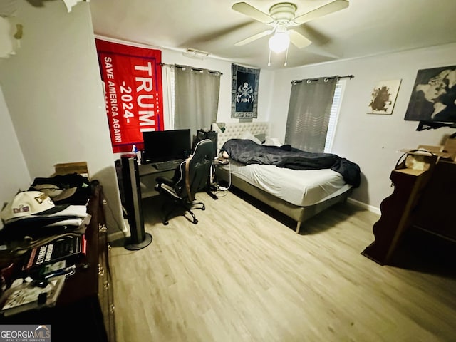 bedroom with wood finished floors, baseboards, and a ceiling fan