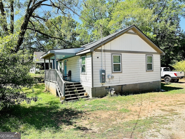 view of property exterior with a yard and covered porch