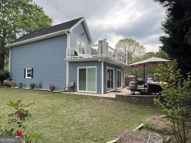 back of house featuring a yard, a patio area, and a balcony