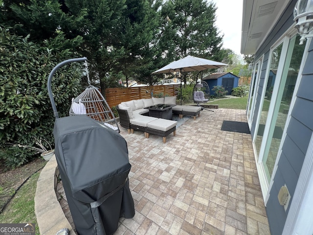 view of patio featuring a shed, an outdoor living space with a fire pit, area for grilling, fence, and an outbuilding