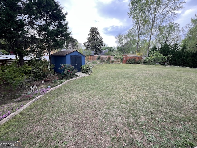 view of yard with an outbuilding, a shed, and fence