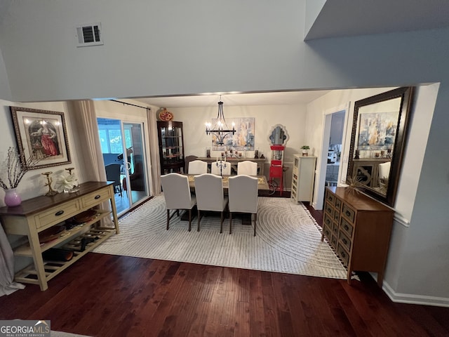 dining space featuring visible vents, baseboards, an inviting chandelier, and wood finished floors