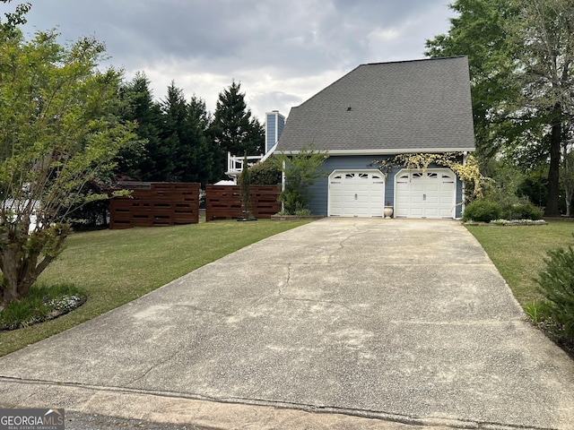 view of side of property with a yard, roof with shingles, driveway, and a chimney