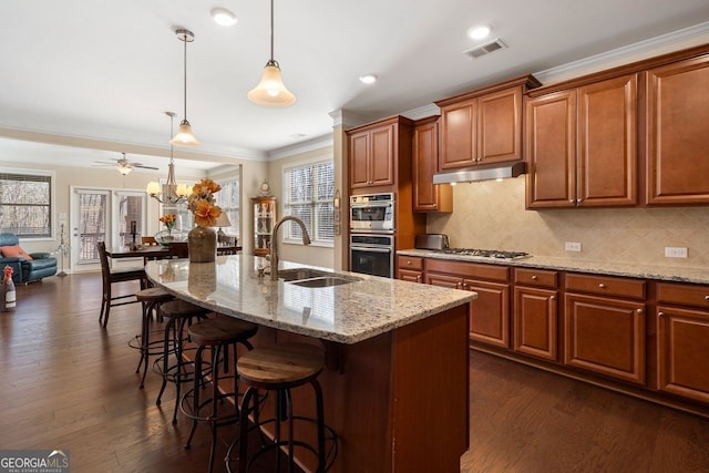 4538 Sterling Pointe Dr NW, Kennesaw, GA 30152 - kitchen with a sink, crown molding, a kitchen bar, light stone countertops, and under cabinet range hood