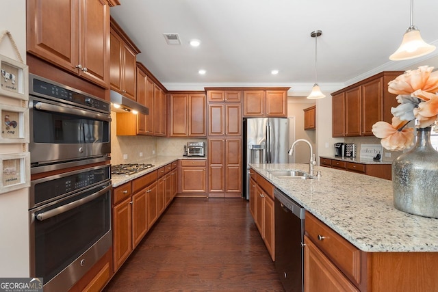 4538 Sterling Pointe Dr NW, Kennesaw, GA 30152 - kitchen with stainless steel appliances, a sink, under cabinet range hood, brown cabinets, and recessed lighting