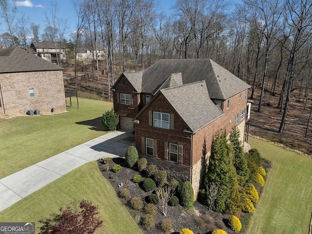 4538 Sterling Pointe Dr NW, Kennesaw, GA 30152 - view of side of home featuring concrete driveway, brick siding, a yard, an attached garage, and a shingled roof