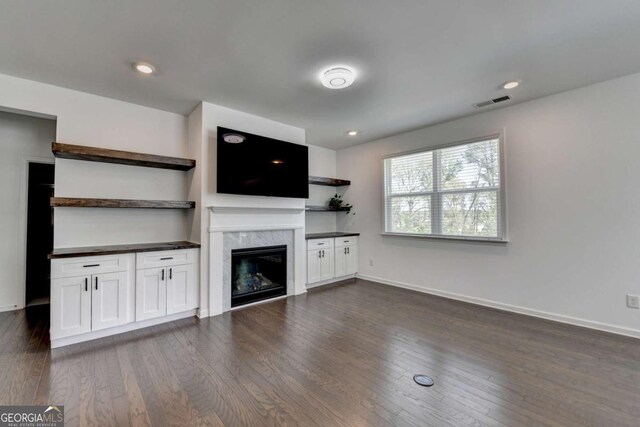 5530 Bower Pl, Cumming, GA 30028 - unfurnished living room featuring dark wood-type flooring, visible vents, a high end fireplace, and baseboards