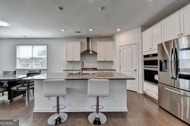 5530 Bower Pl, Cumming, GA 30028 - kitchen featuring wall chimney range hood, white cabinetry, visible vents, appliances with stainless steel finishes, and a sink