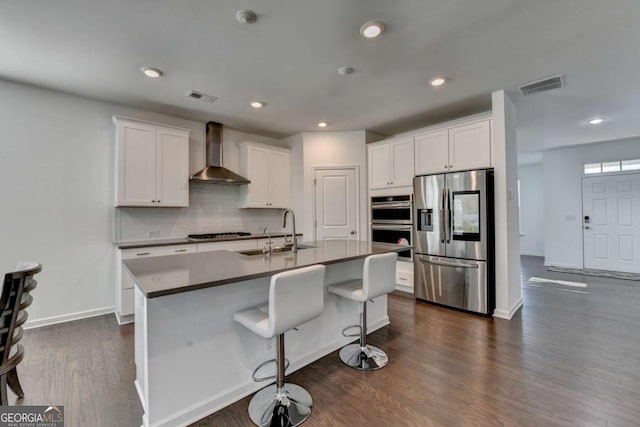 5530 Bower Pl, Cumming, GA 30028 - kitchen with visible vents, wall chimney exhaust hood, a sink, stainless steel appliances, and decorative backsplash