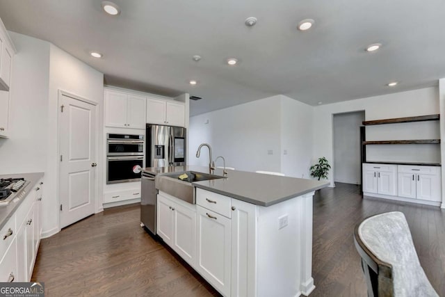 5530 Bower Pl, Cumming, GA 30028 - kitchen with stainless steel appliances, white cabinetry, a sink, and dark wood finished floors