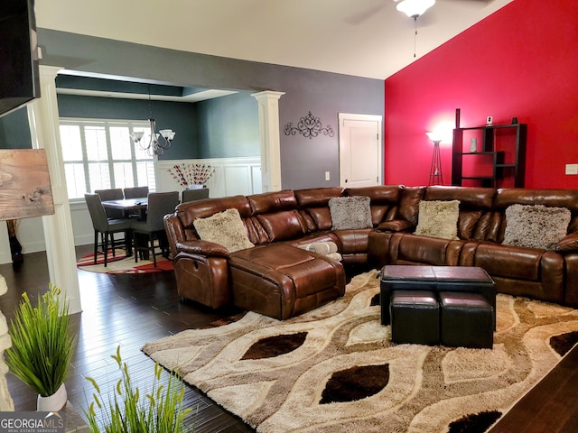 living room featuring ornate columns, wood-type flooring, wainscoting, high vaulted ceiling, and ceiling fan with notable chandelier