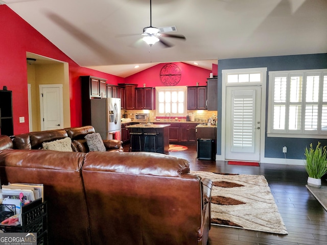 living area with vaulted ceiling, a ceiling fan, visible vents, baseboards, and dark wood-style floors