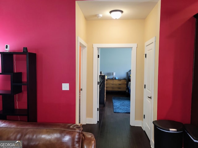 hallway featuring baseboards and dark wood-style floors