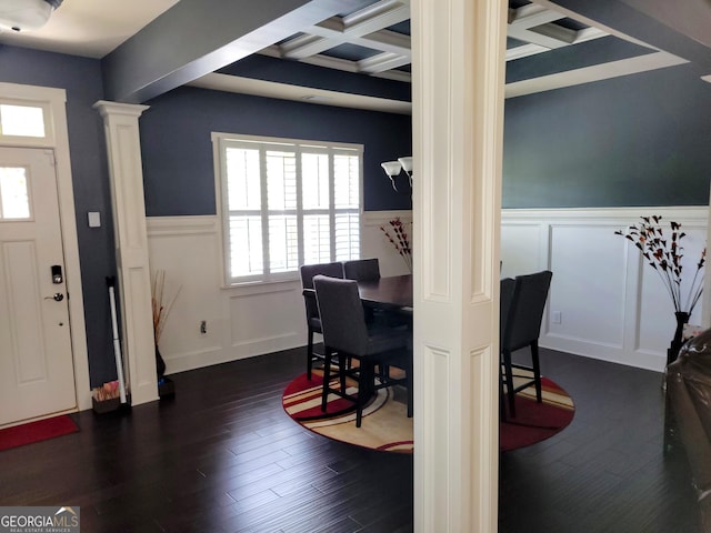 dining area featuring a decorative wall, decorative columns, beamed ceiling, a wainscoted wall, and coffered ceiling