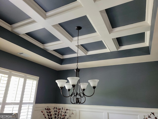 room details featuring crown molding, wainscoting, an inviting chandelier, coffered ceiling, and visible vents