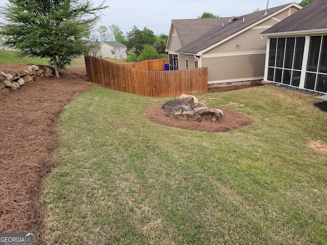 view of yard featuring a sunroom and fence