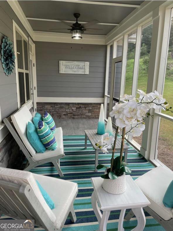 sunroom / solarium featuring a ceiling fan