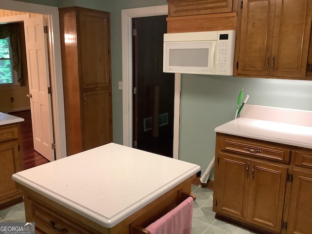 10 Horseshoe Bend Rd SW, Rome, GA 30165 - kitchen featuring white microwave, brown cabinetry, and light countertops