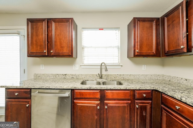kitchen with dark brown cabinets, light stone counters, dishwasher, and a sink