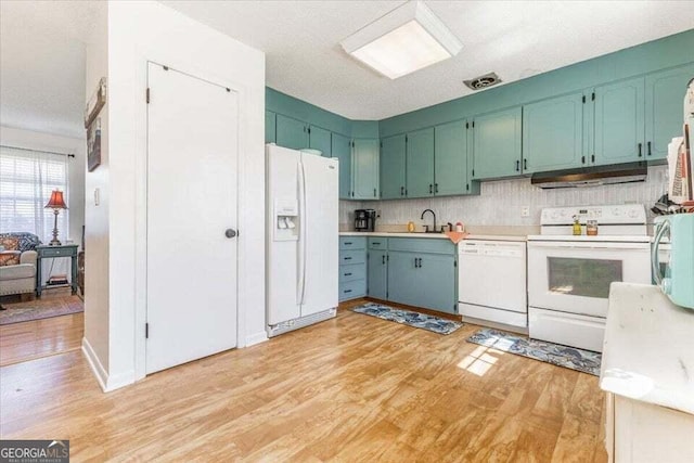 kitchen featuring a sink, light wood-style floors, white appliances, light countertops, and under cabinet range hood