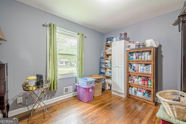 interior space with visible vents, baseboards, and wood finished floors