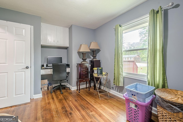 home office with wood finished floors and baseboards