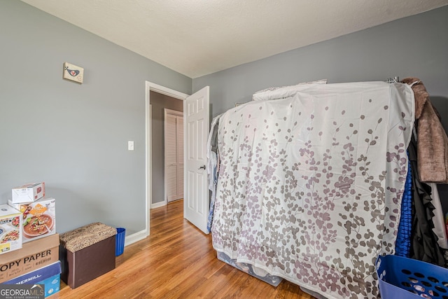 bedroom featuring light wood finished floors and baseboards