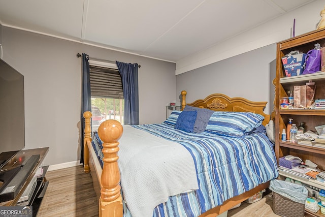 bedroom with baseboards and wood finished floors