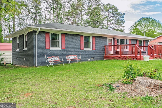 back of property featuring a yard, a wooden deck, brick siding, and crawl space