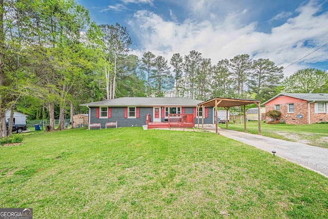 ranch-style home featuring driveway, a front lawn, brick siding, a wooden deck, and fence