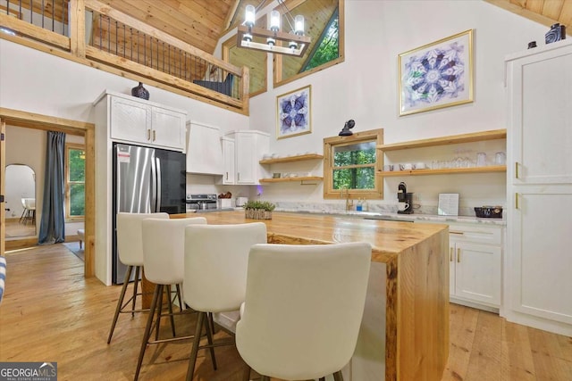 318 Lees Ride Unit 8, Mccaysville, GA 30555 - kitchen featuring white cabinets, open shelves, a center island, wooden counters, and high vaulted ceiling