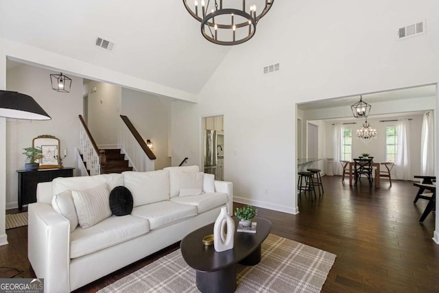 living area featuring a chandelier, stairs, and visible vents