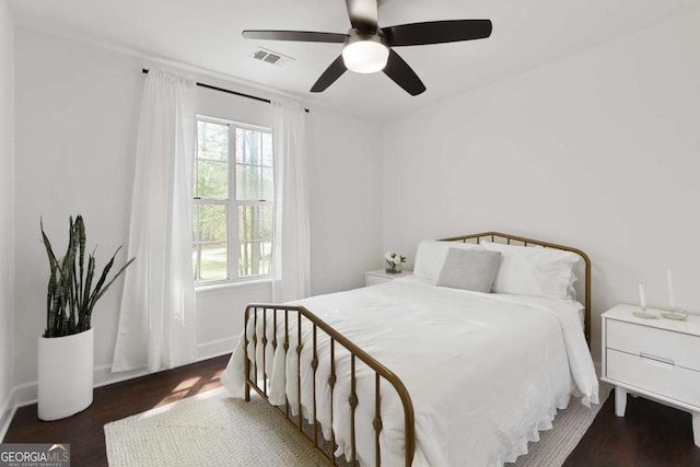 bedroom with visible vents, ceiling fan, wood finished floors, and baseboards