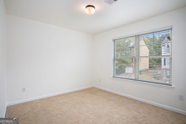 spare room featuring carpet flooring and baseboards