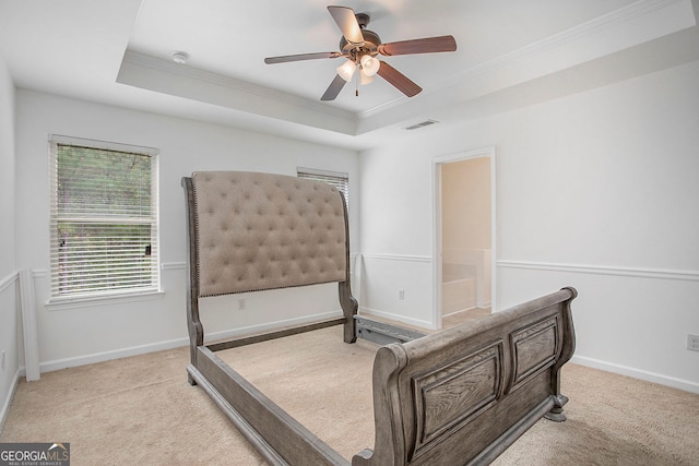 carpeted bedroom featuring ornamental molding, baseboards, a raised ceiling, and visible vents