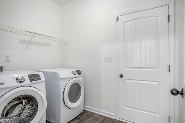 clothes washing area with dark wood-style flooring, independent washer and dryer, laundry area, and baseboards