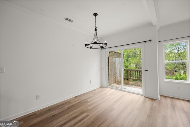 unfurnished dining area featuring visible vents, baseboards, a chandelier, crown molding, and wood finished floors