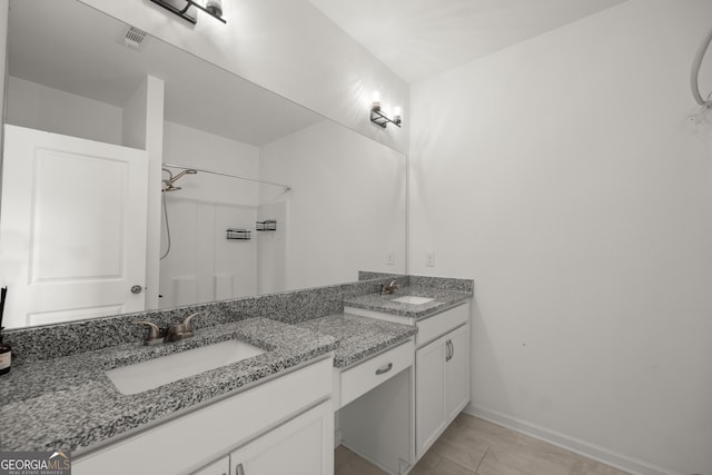 full bath featuring vanity, baseboards, walk in shower, and visible vents