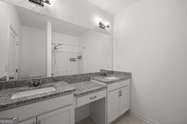 bathroom with toilet, vanity, baseboards, and walk in shower