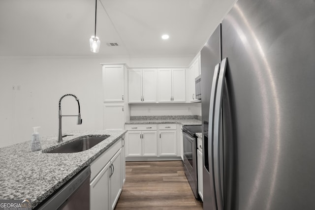 kitchen with crown molding, appliances with stainless steel finishes, a sink, and white cabinetry