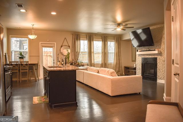 1058 Mays Hl, Atlanta, GA 30336 - living area featuring visible vents, a wealth of natural light, a ceiling fan, and a glass covered fireplace